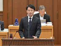 Hyogo Governor Motohiko Saito (front) explains a submitted bill at a plenary session of the Hyogo prefectural assembly in Kobe on Friday.