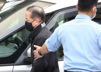 Kenji Nanba, former manager of Nihon University's weightlifting club, is transferred to the Shinagawa station of the Metropolitan Police Department in Tokyo on Tuesday.
