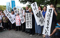 Plaintiffs hold up papers reading 