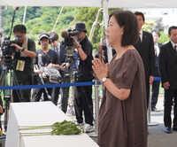 Yoko Koiso, a bereaved family member, Thursday offers flowers in a memorial ceremony for the victims of the 2021 mudslide disaster in Atami, Shizuoka Prefecture.