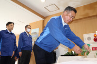 Mayor Koichi Matsutani offers flowers at the Kuma village hall on the fifth anniversary of the Kumamoto heavy rains on Friday.