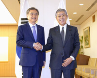 Japanese Foreign Minister Takeshi Iwaya (right) and South Korean Foreign Minister Cho Hyun shake hands in Tokyo on Tuesday. (Pool photo)