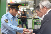 Hachioji Police Station chief Fumiaki Shirozono (far left) asks for information about the 1995 triple murder in front of JR Hachioji Station on Wednesday.