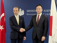 Japanese Justice Minister Keisuke Suzuki (right) shakes hands with Turkish Ambassador to Japan Oguzhan Ertugrul at the Justice Ministry in Tokyo on Wednesday.