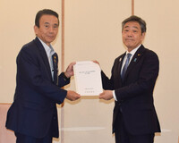 Japanese Deputy Chief Cabinet Secretary Kazuhiko Aoki (right) receives a proposal on accepting foreign nationals from Shizuoka Governor Yasutomo Suzuki in Tokyo on Wednesday.