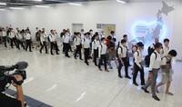 Extradited fraud suspects are escorted by investigators at Chubu Centrair International Airport in Aichi Prefecture on Wednesday.